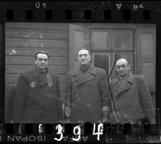 Mr. Elefant, Transport Department administrator, and two men standing outside a window in the ghetto