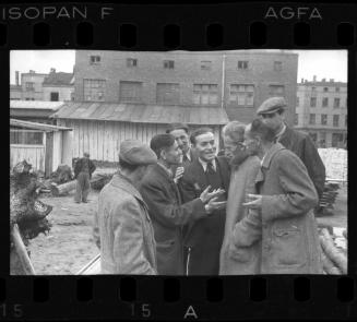 Members of the ghetto administration talking in a yard in the ghetto