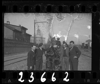 Group of men posing with a horse and carriage in the street