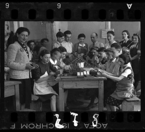 Children at work making accessories by hand, Mrs. M. Bronowska supervisor