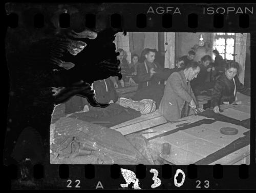 Men and women workers cutting fabric in a workshop in the ghetto