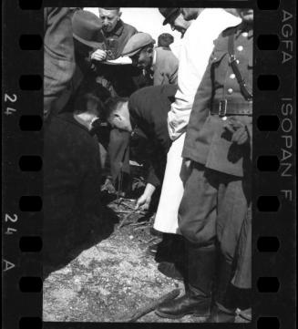 Officials and residents inspecting twigs, after liberation