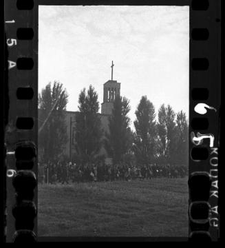 Massive deportation of residents from the Lodz ghetto walking by a church