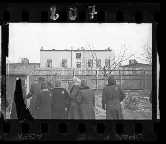 Group of residents with Jewish policeman or postman gatherd in a yard in winter