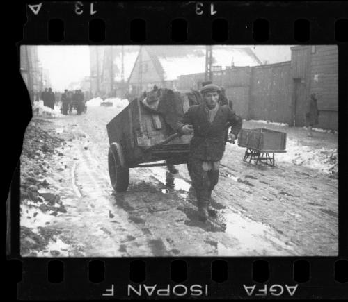 Man hauling a cart through the street