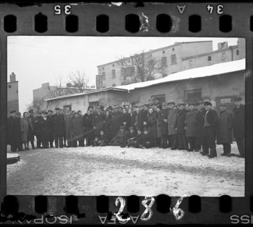 Large group of men and women workers and administrators of the Transport Department in the ghetto in winter