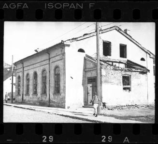 Unidentified building in the ghetto with a girl walking by