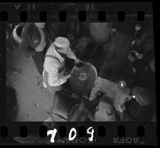 Cook ladling soup into pail
