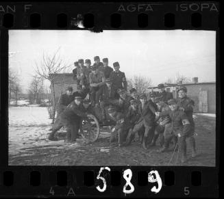 A group of Jewish police posing with a wooden cart, in winter