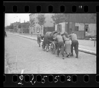 Fecal workers hauling a sewage collecting tank mounted on a wagon through the ghetto