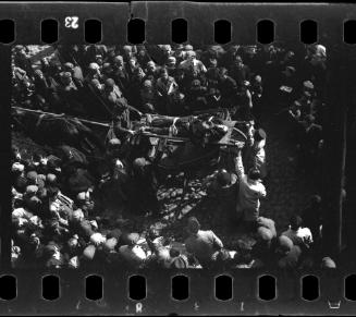 A corpse carried through a crowd of residents in the ghetto