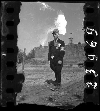 A young Jewish policeman standing in a field