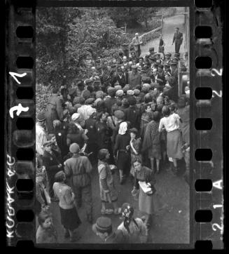 Mordechai Chaim Rumkowksi, "Elder of the Jews" and Chairman of the Judenrat, speaks to a crowd, surrounded by ghetto police