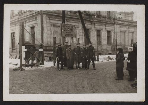 Lodz Ghetto liberated, residents standing freely at restricted Juden gate