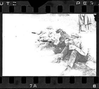 Residents sitting on roadside eating from pails