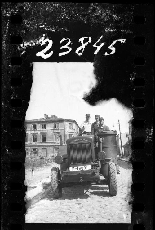 Four men riding a tractor through the ghetto