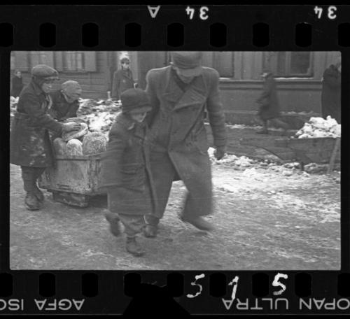 Man and boys moving cart with bread