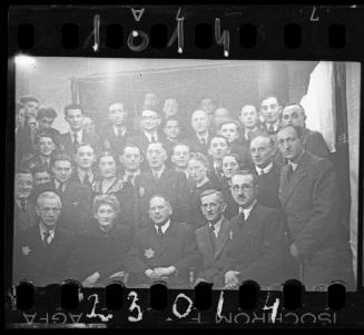 Large group portrait of well dressed men and women [probably members of the Judenrat, the Jewish Council]