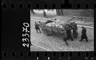 Men moving wagon with sacks