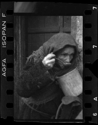 Elderly woman eating from pot