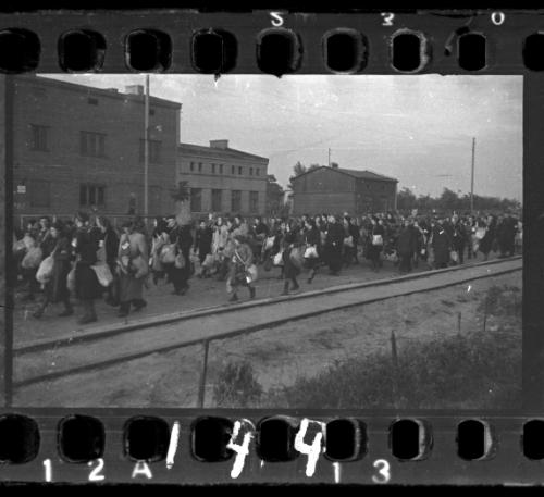 Mass deportation walking alongside train tracks