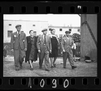 Three men and two women walking