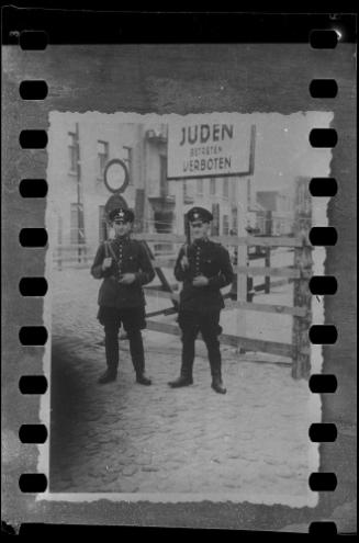 German officials standing under 'Juden Betreten Verboten' sign