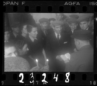 Man reading to a group, with residents holding candles
