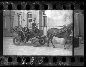Two men riding in a carriage in the ghetto