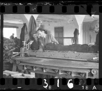 A worker and an administrator examining hide in the leather factory