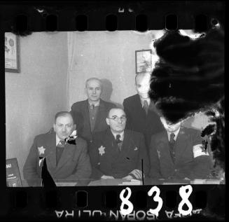 Jewish police officer and members of the ghetto administration in an office