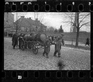 Fecal workers hauling a sewage collecting tank mounted on a wagon through the ghetto