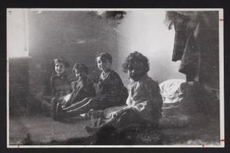 Four children sitting on floor mats