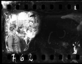 Jewish policeman holding his infant, beside three women