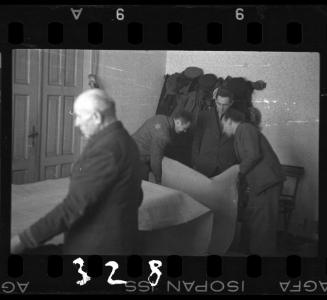 Men examining bolts of fabric in a workshop in the ghetto