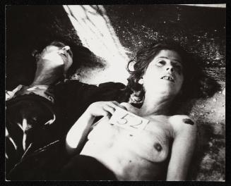 Bodies for burial one tagged '52' - Two women, one without shirt