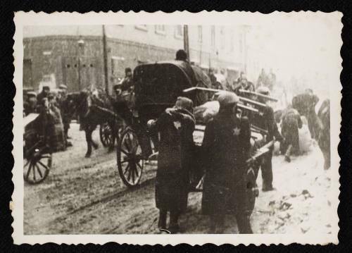 Workers moving cart through snow covered street