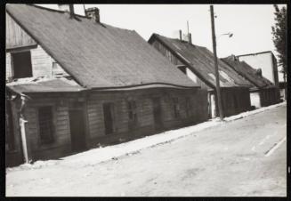 Empty road and wooden houses with chimneys