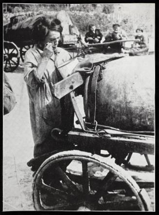 Female fecal worker standing and eating from pail