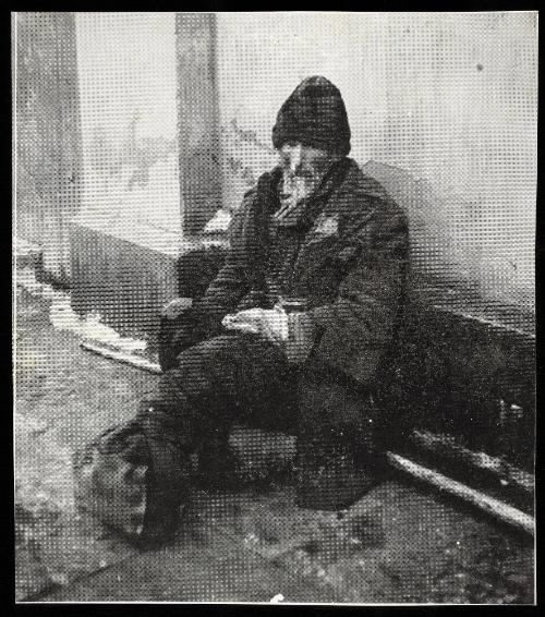 Elderly man on street with feet bundled in rags