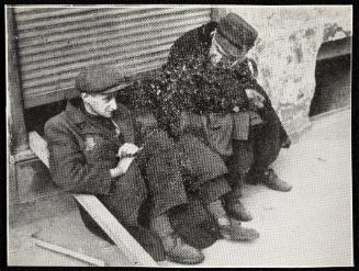 Two men sitting on street