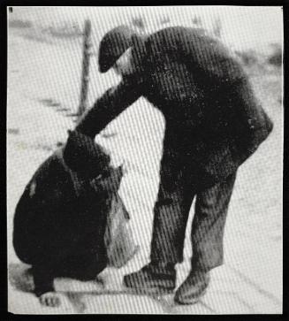 Man assisting woman who has fallen on street