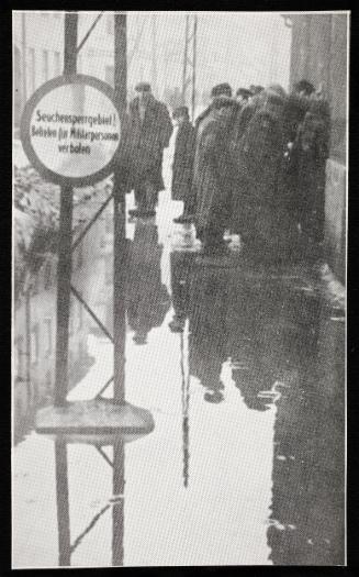 Line up with a puddle in the foreground, and a sign in German