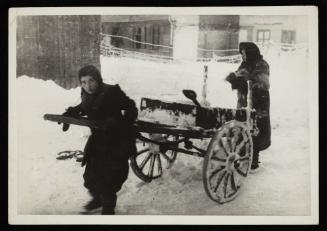 Two women pushing cart through snow