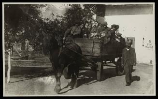 Man walking alongside horse-drawn labour wagon
