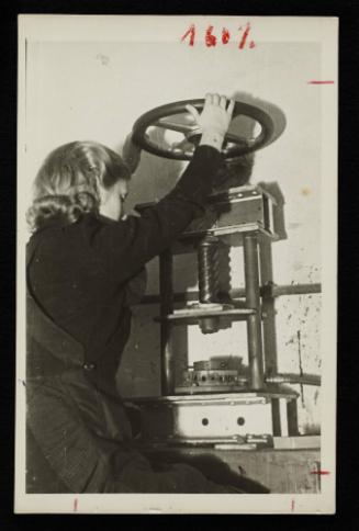 Female worker operating roll press