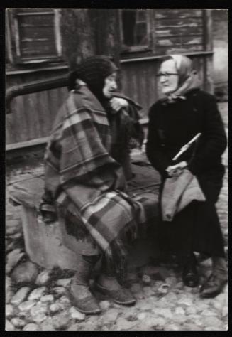 Two women in conversation, sitting on street bench