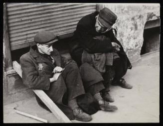 Two men sitting on street