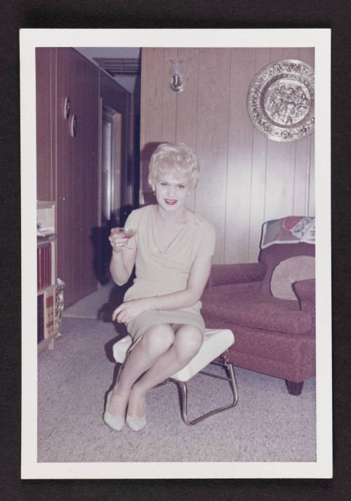 [In a tan dress with cocktail, location unknown]
