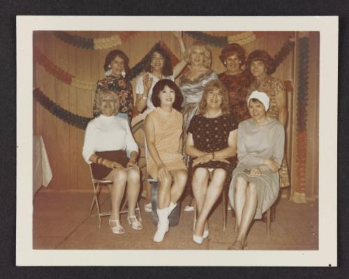 [Kathey, Susanna, Jody, Ann, Lili, and four friends posing in front of decorations, location unknown]
